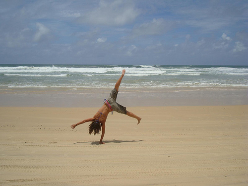 woman cartwheeling, cartwheelon beach